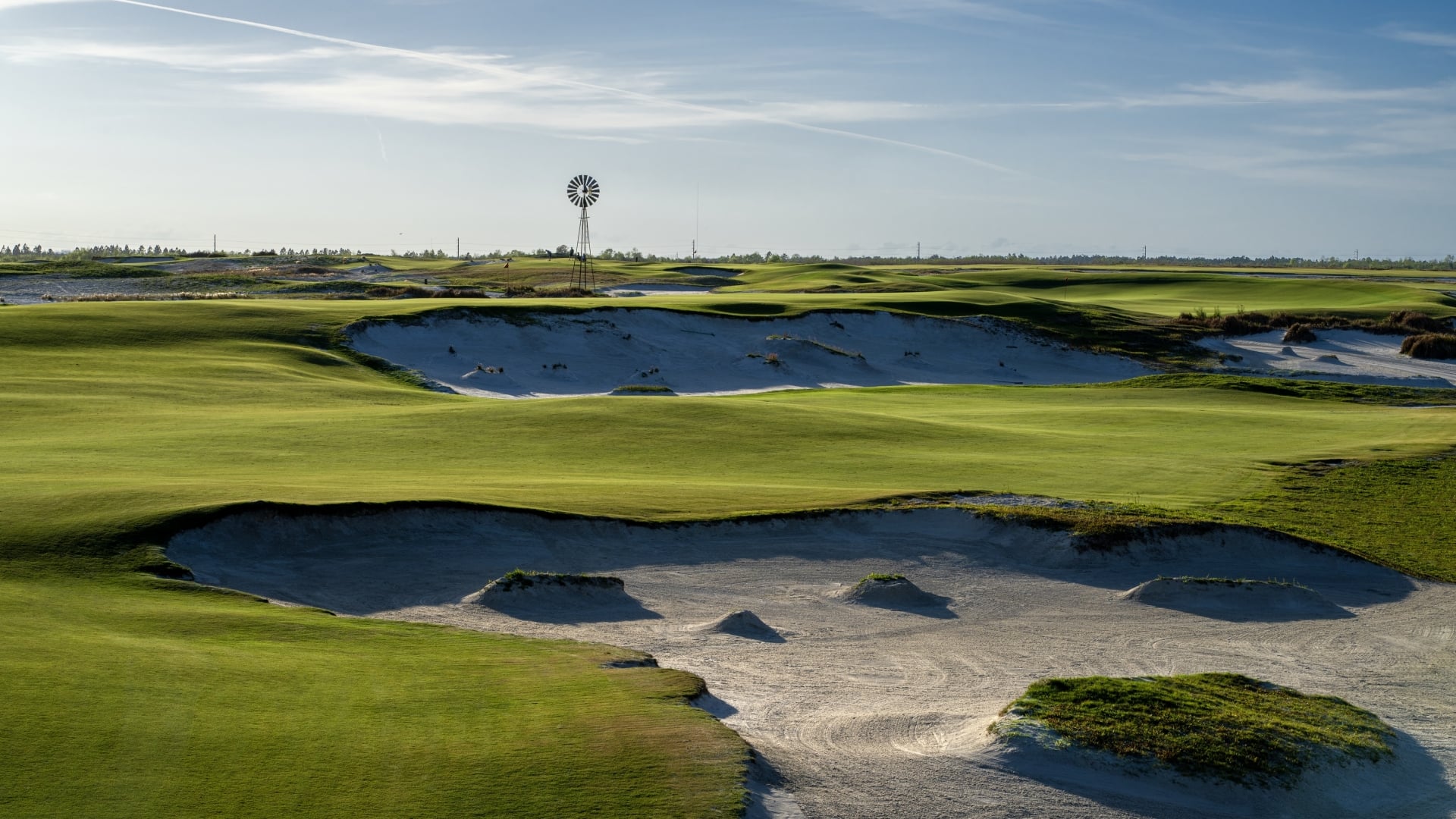 Hole 2 of Streamsong Black with a windmill on the horizon